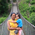 Frau mit Kind auf Hängebrücke