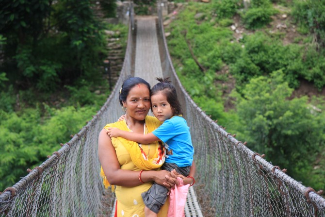 Frau mit Kind auf Hängebrücke